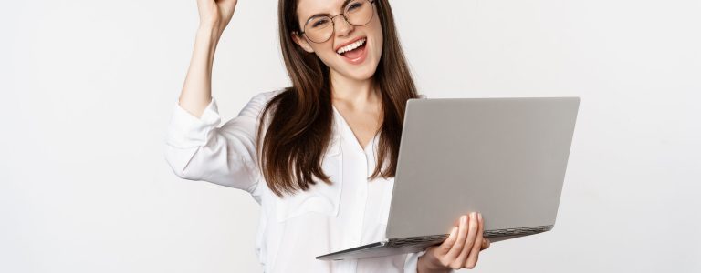 Enthusiastic office woman, businesswoman holding laptop and shouting with joy, celebrating and rejoicing, standing over white background.